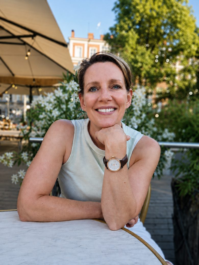 Gina Riley, founder of Gr8tStep, seated at an outdoor table and smiling.